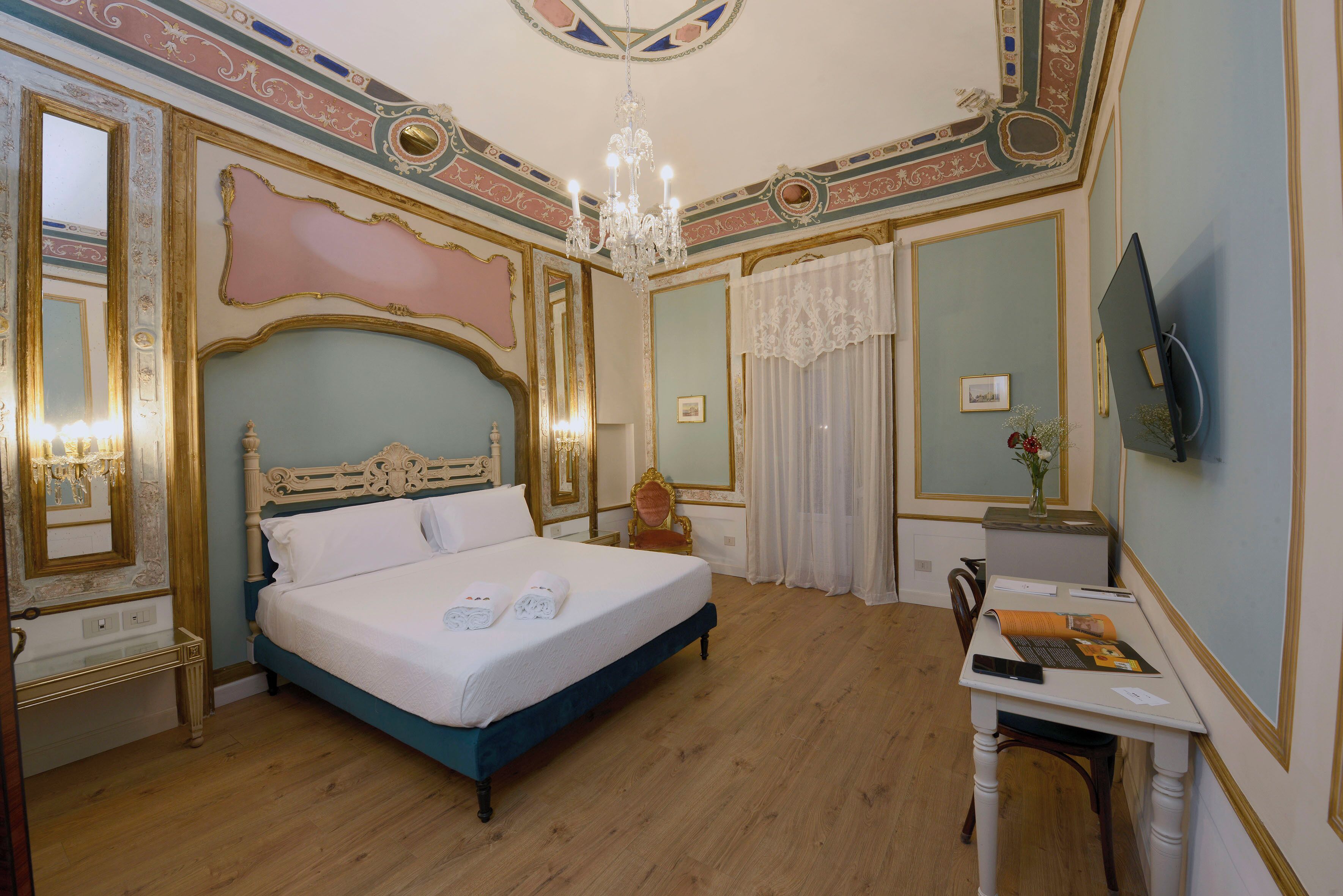 Ein Schlafzimmer mit einem großen Bett, einem Schreibtisch und einer Deckenleuchte.