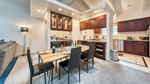 A modern kitchen with wooden cabinets, a dining table, and chairs.
