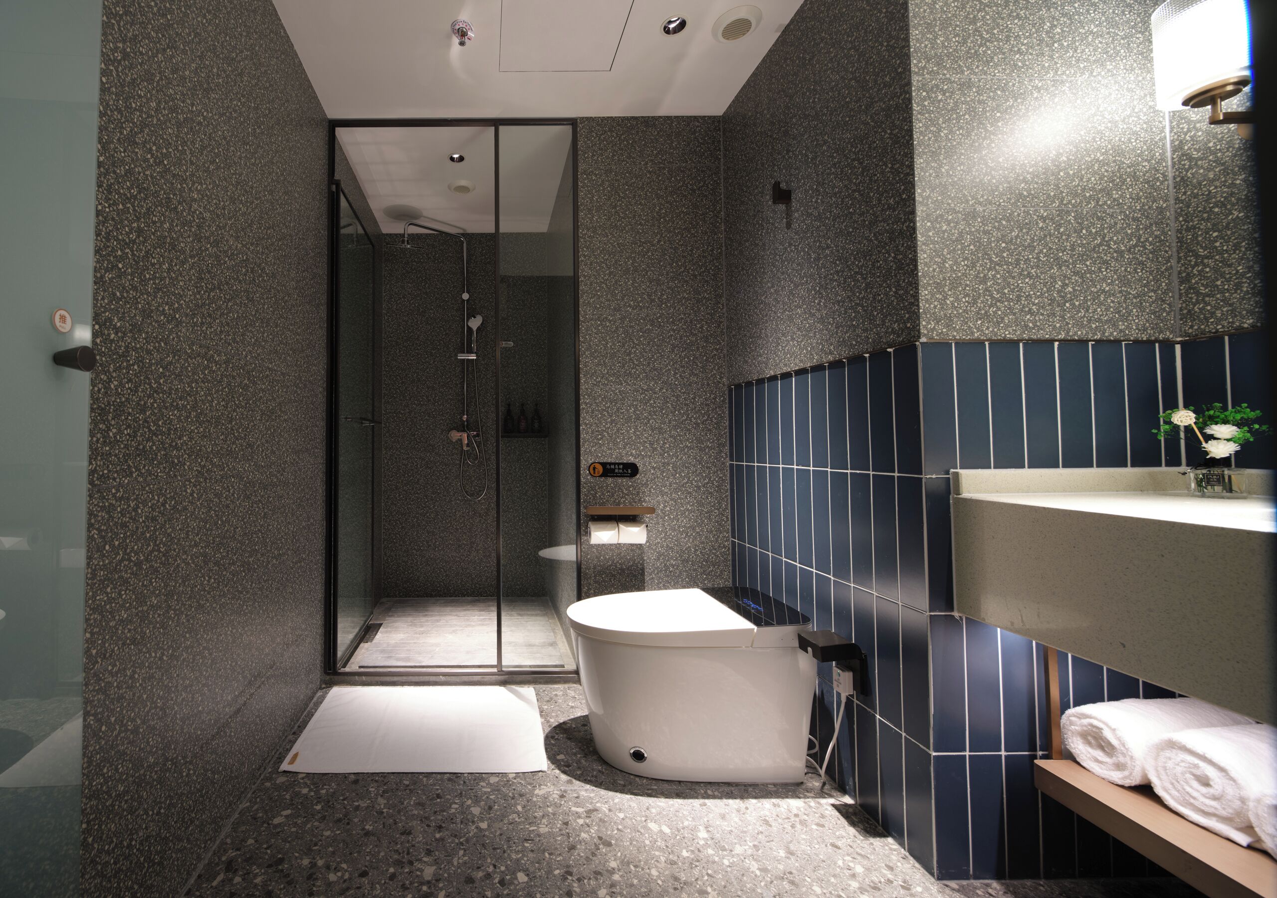 A modern bathroom with a freestanding bathtub, a glass-enclosed shower area, and a vanity with a towel rack.