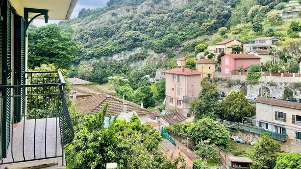 Un quartier résidentiel situé sur une colline, avec des maisons dont certaines ont des toits rouges et d’autres des toits gris.