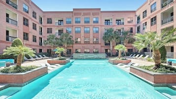 Relax by the pool surrounded by lush greenery and palm trees in our central courtyard.