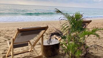 On the beach, white sand, sun-loungers, beach towels
