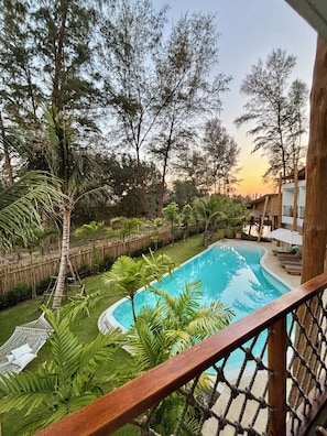 Una piscina rodeada de exuberante vegetación y una terraza de madera.