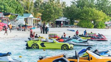 A beach with water sports vehicles and people.