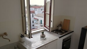 A kitchen with a window, a kettle, and a refrigerator. - Rooftop mansion (Palermo)