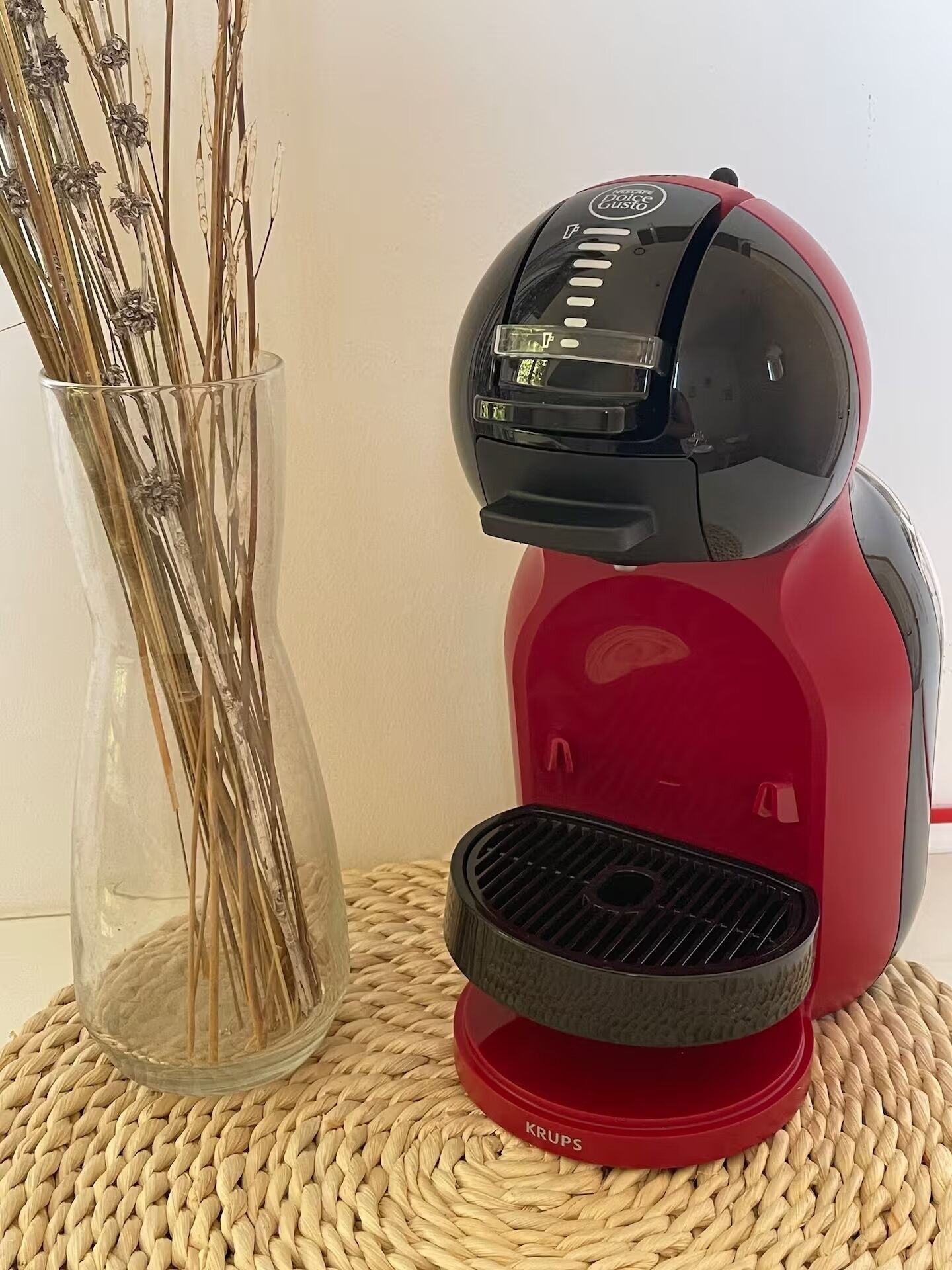 Eine rote Krups-Kaffeemaschine auf einer gewebten Unterlage.