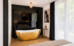 A modern bathroom with a freestanding bathtub, a large mirror, and a framed artwork on the wall. - Arena Park Bucharest (Bucharest)