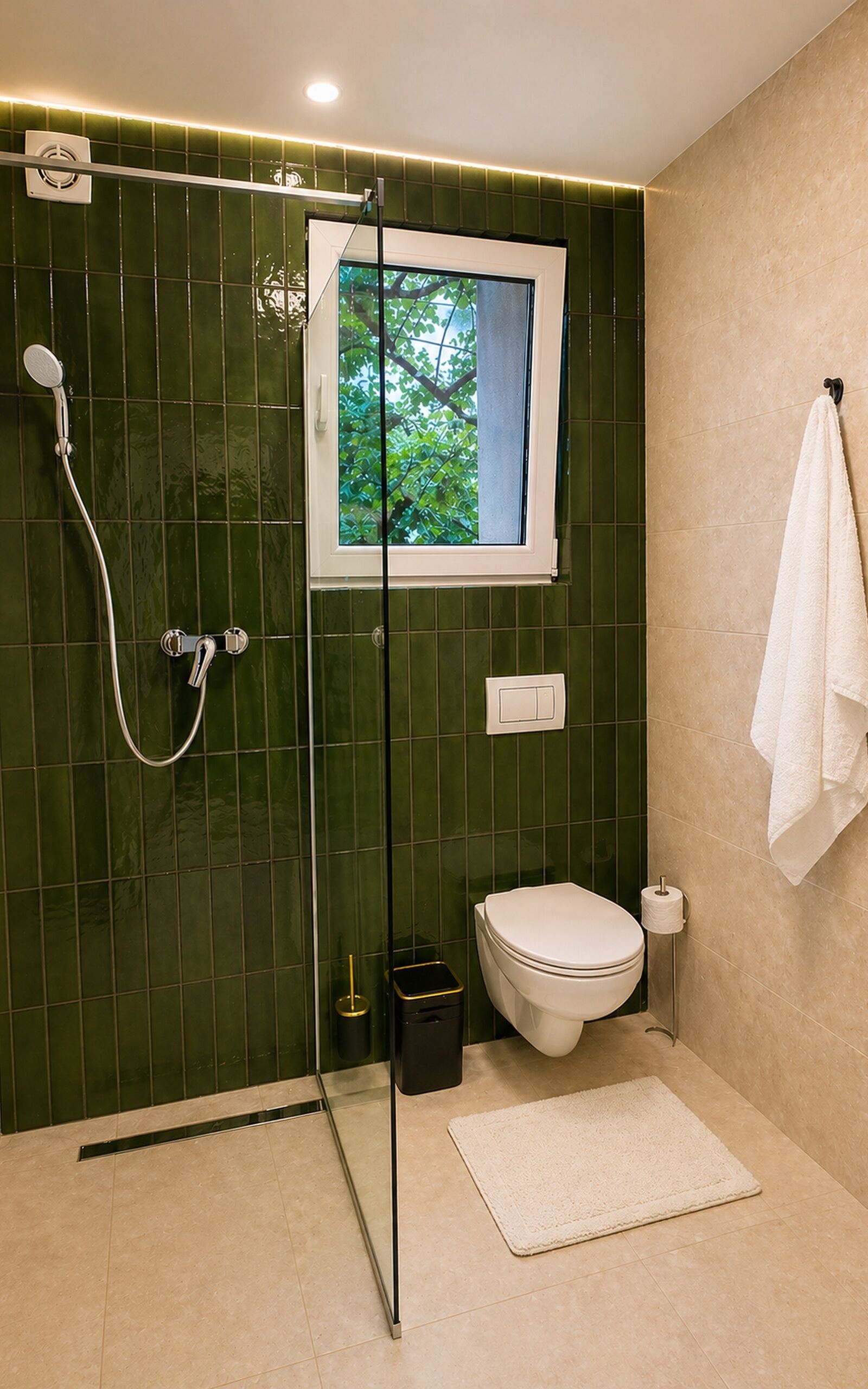 Ein Badezimmer mit Duschkabine, Toilette, Fenster mit Blick und Handtuchhalter.
