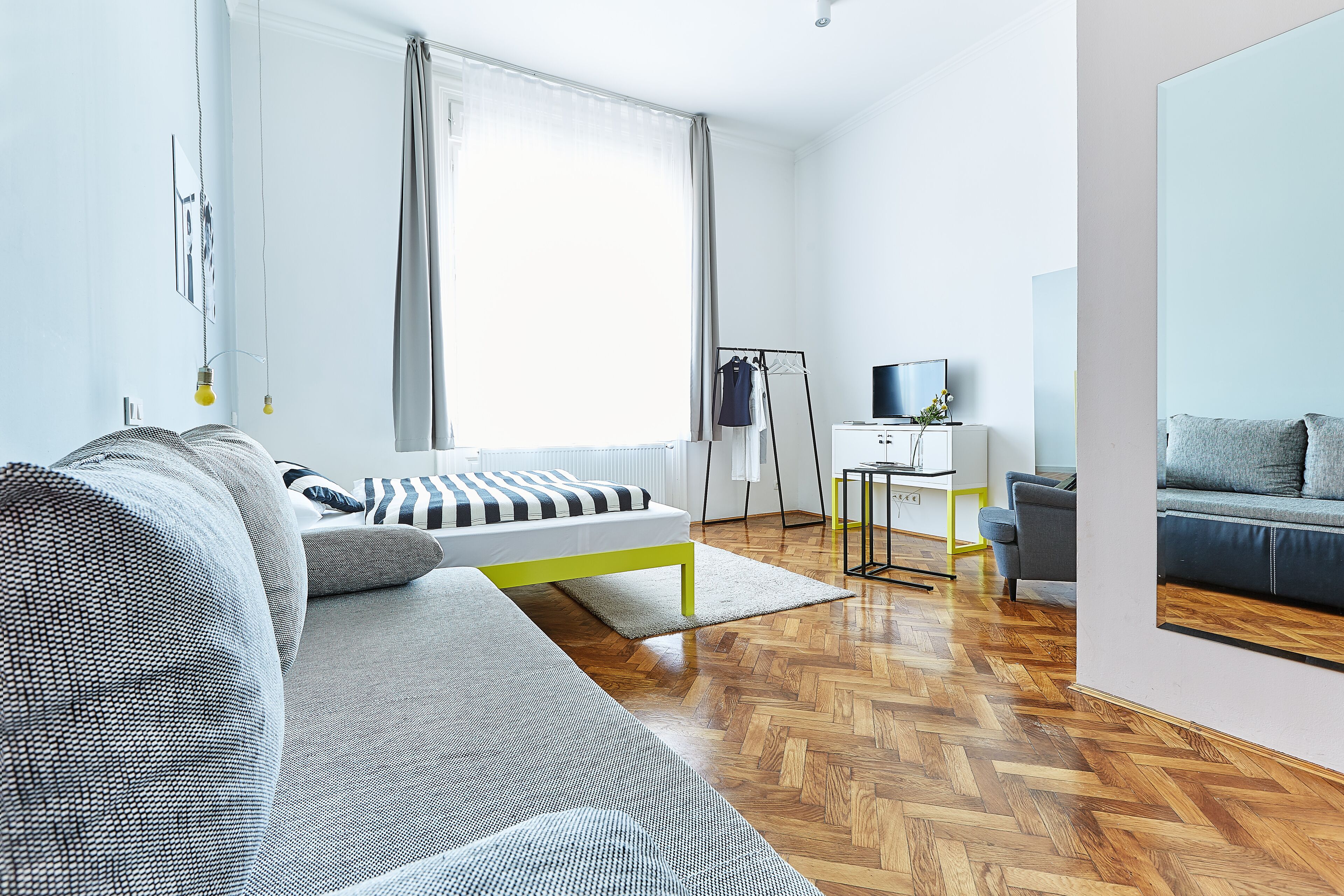 Una sala de estar moderna con un sofá, un televisor y un comedor.