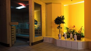 A reception area with a wooden bench, a reception desk, and potted plants. - Altwernigeröder Apparthotel  (Wernigerode)