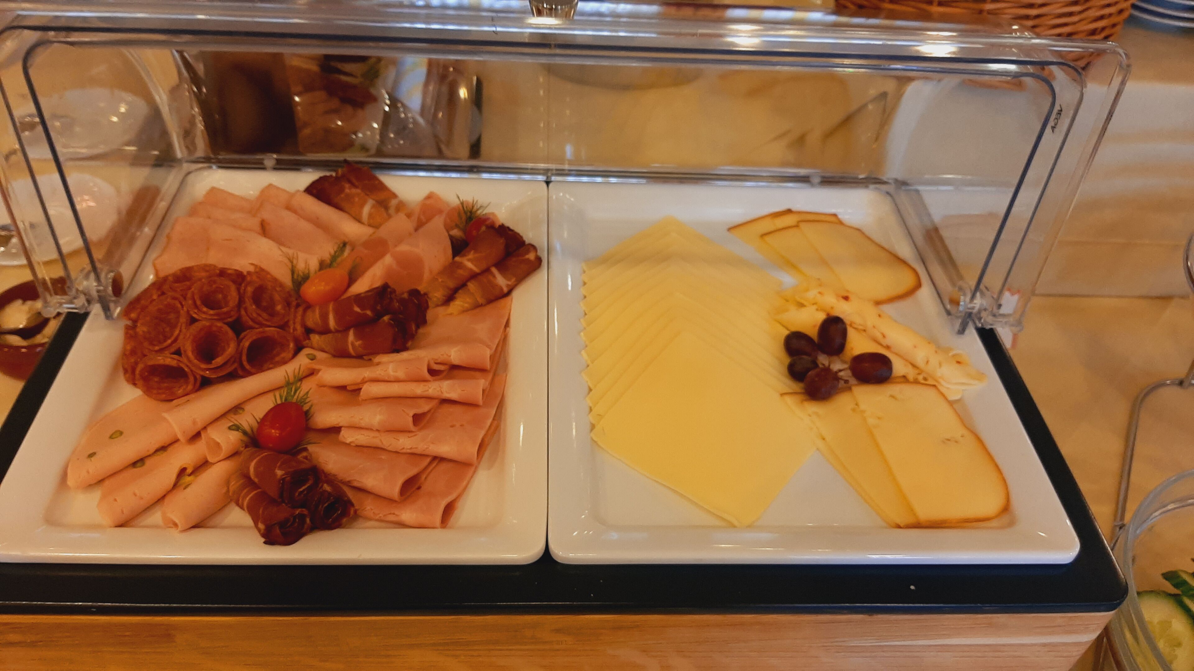 A buffet with various meats and cheeses.