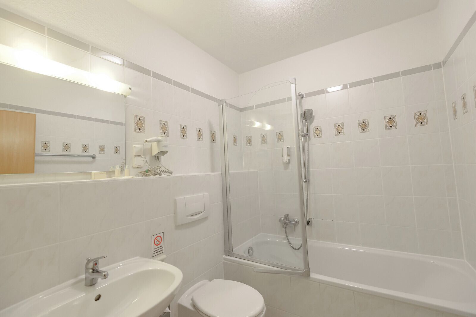 A bathroom with a shower, toilet, and sink.
