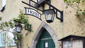 A hotel entrance with a green door, a sign above the door, and a small window with a menu board. - Altwernigeröder Apparthotel  (Wernigerode)