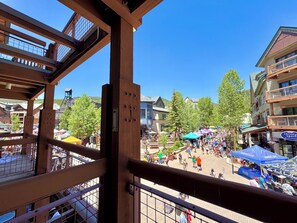 Un vivace mercato all'aperto con strutture in legno e un cielo azzurro.