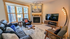 A living room with a fireplace, a television, and leather sofas. - Trappers Crossing 8769 (Keystone)