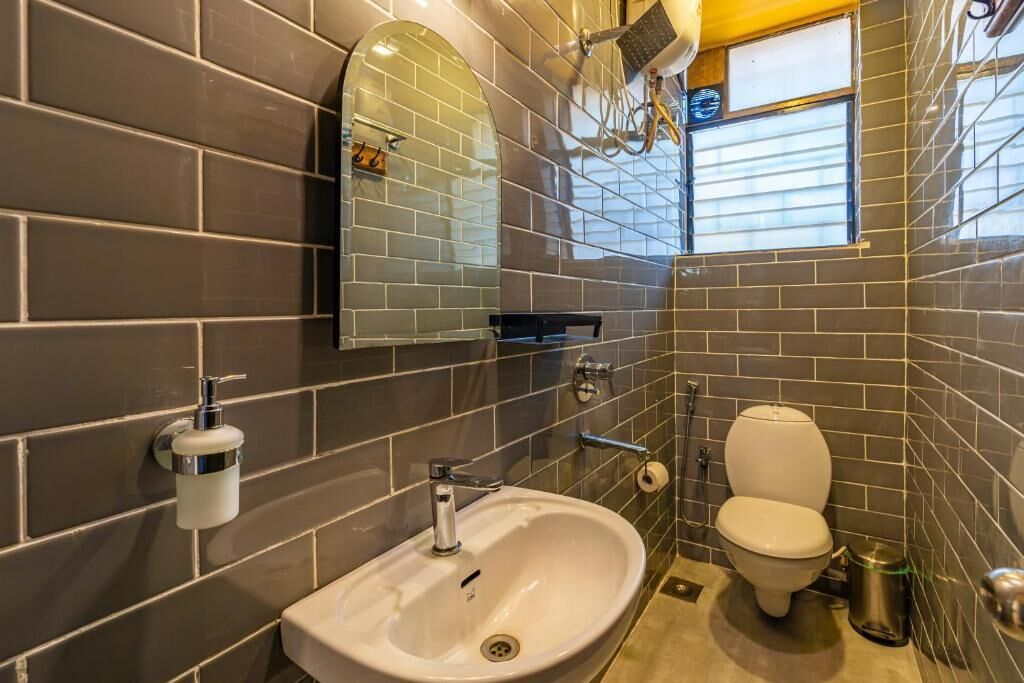 Un baño con lavamanos, inodoro y espejo.