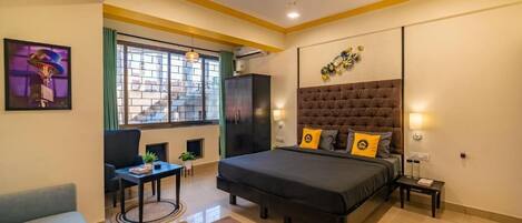 Un dormitorio moderno con una cama grande, un escritorio y un sofá.