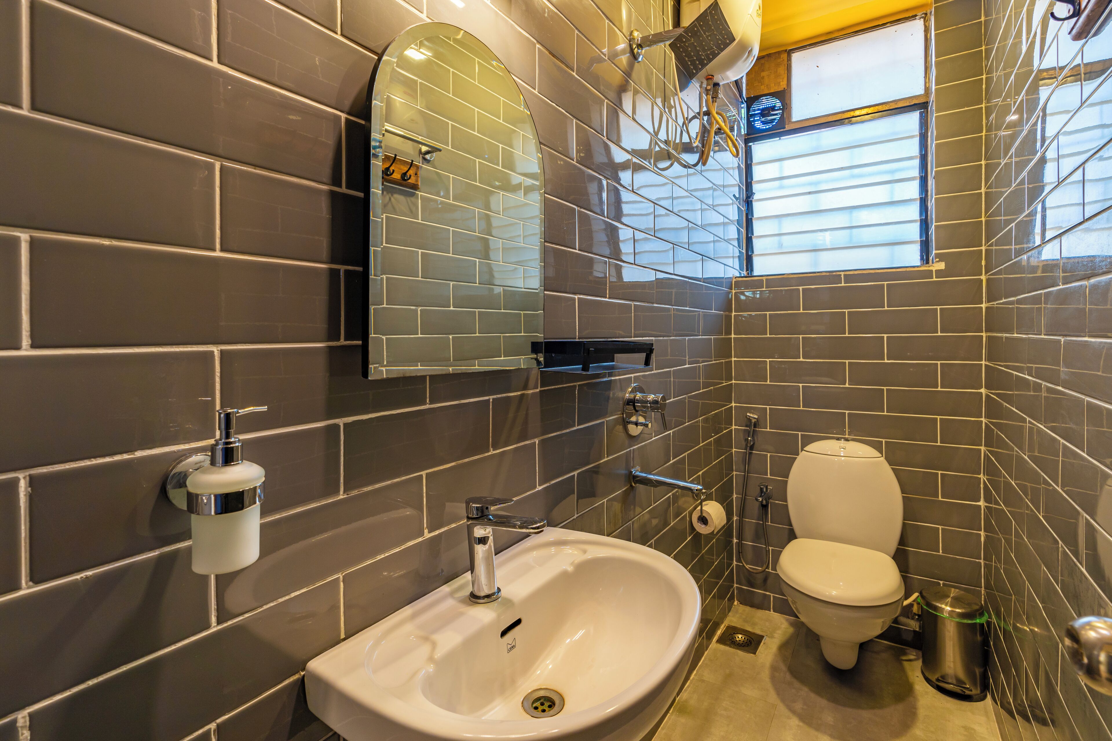 A bathroom with a sink, toilet, and mirror.