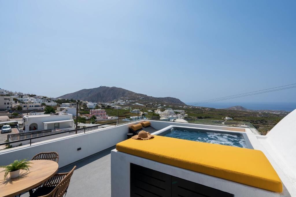Une terrasse sur le toit équipée d’un jacuzzi, d’un espace salon et offrant une vue sur la côte et les bâtiments.