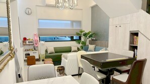 Ett kompakt bostadsutrymme med en matplats, ett litet kök och en sittgrupp.