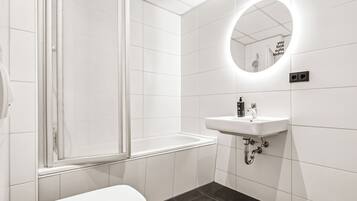 A modern bathroom with a toilet, a sink, and a shower.