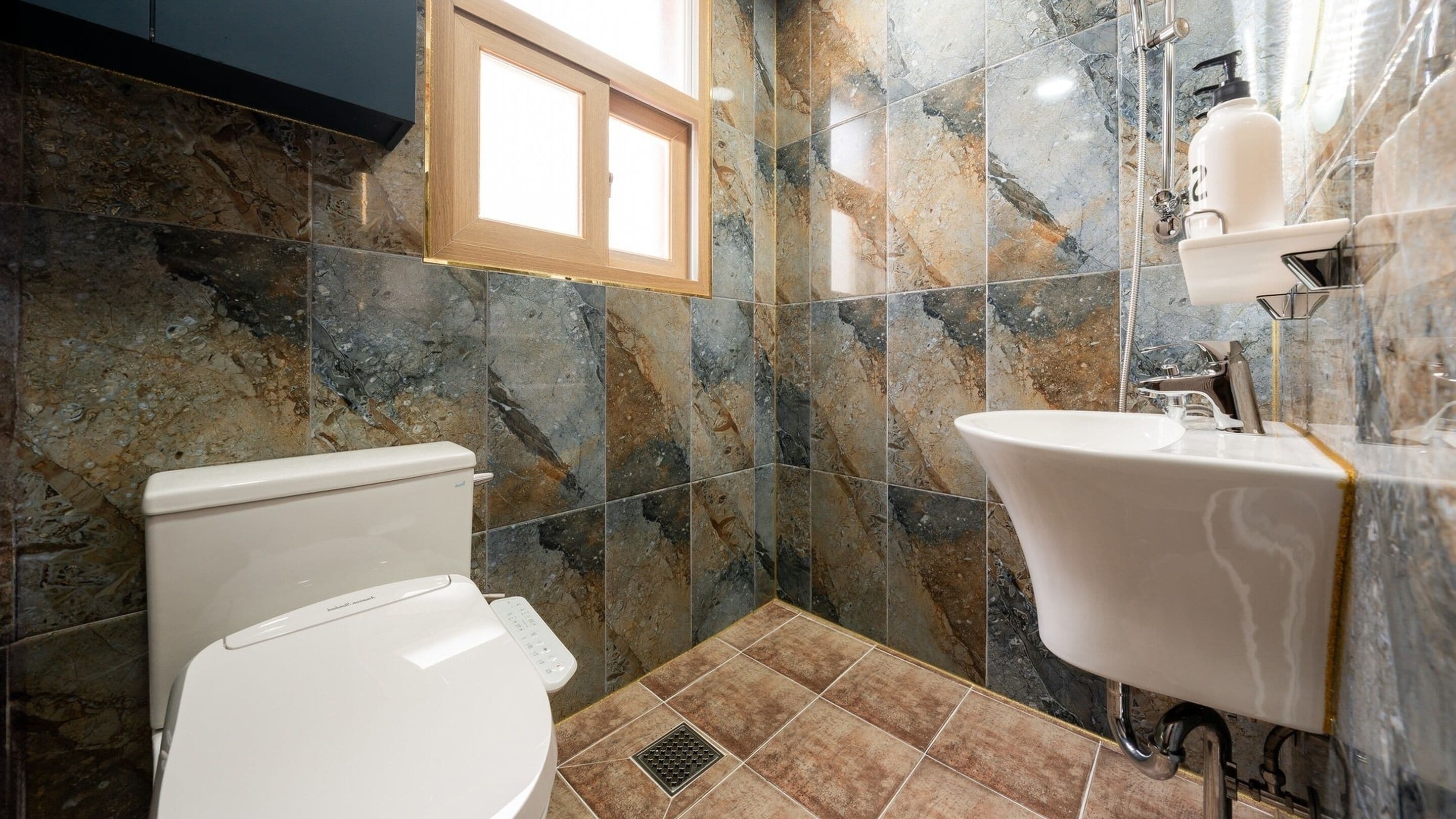A bathroom with a toilet, sink, and shower.
