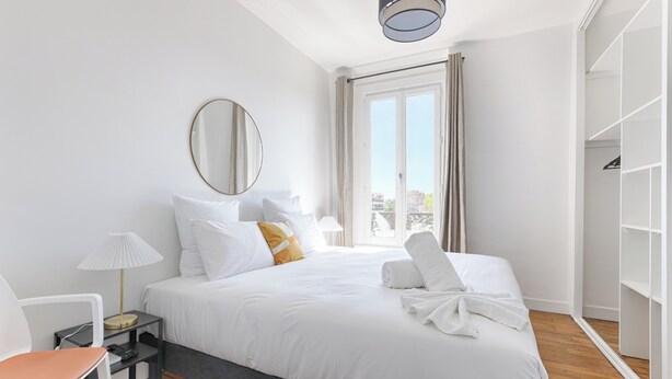 A hotel room with a bed, a chair, a desk, a lamp, a mirror, and a wardrobe. - Apartments in Champigny-Sur-Marne - 30 minutes from Disneyland (Champigny-sur-Marne)