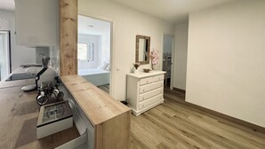 Een moderne keuken met een houten aanrecht, een wit kastje en een spiegel erboven.