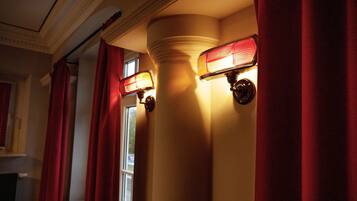 A corridor with red curtains and wall-mounted lights.