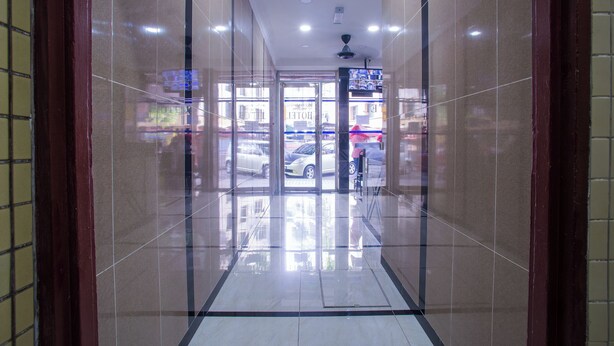 A hallway with a glass door leading to a car parking area. - MK Inn Hotel (Kuala Lumpur)