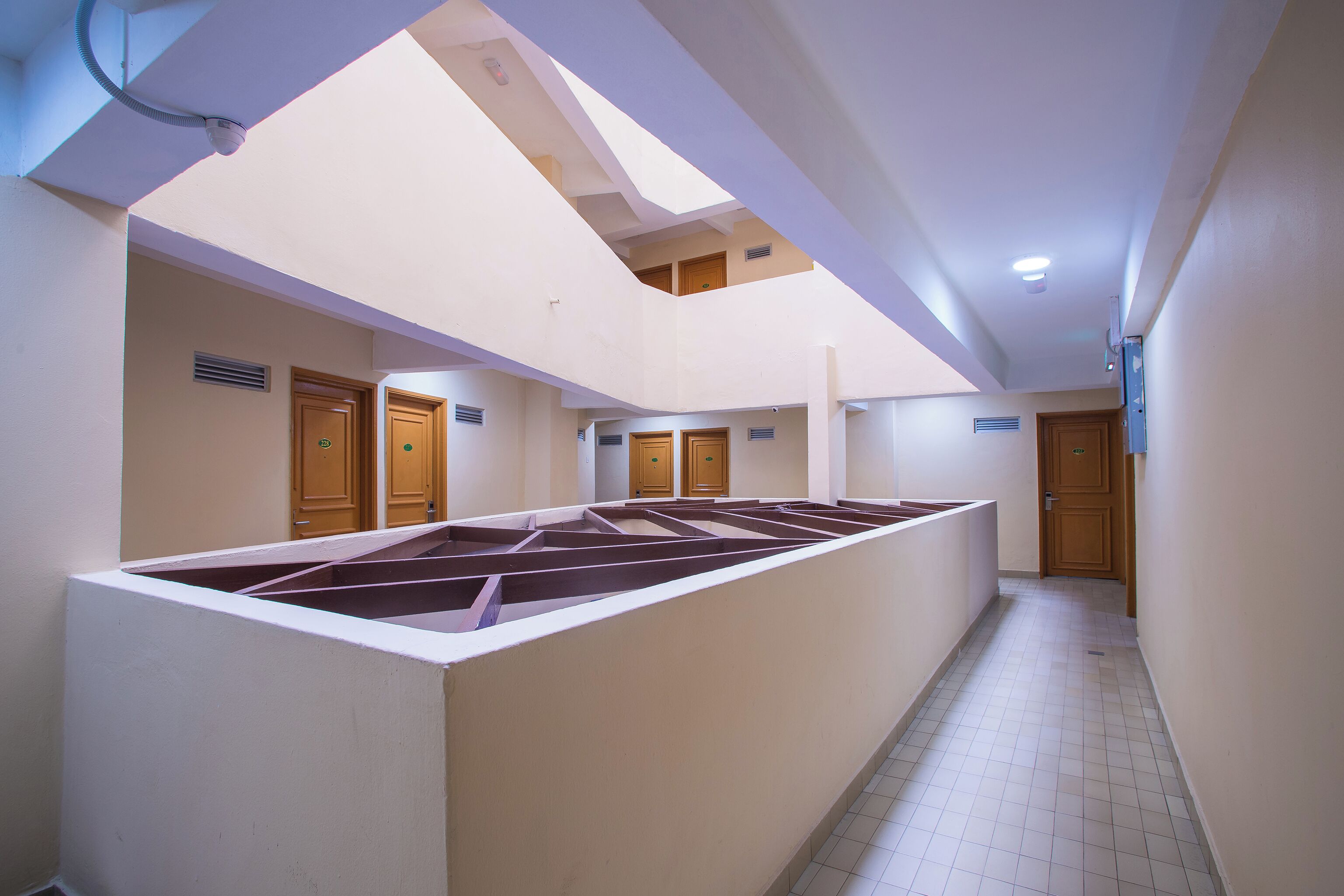 Un interior espacioso con techo alto y un área central abierta, posiblemente para una piscina o espacio de reuniones.
