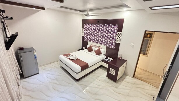 Un dormitorio con cama, mesita de noche y un refrigerador pequeño.