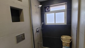 Un baño pequeño con ducha, inodoro y una ventana.