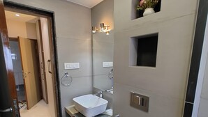 Un baño moderno con un espejo grande, un lavabo blanco y un bidé.