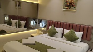 Una habitación de hotel moderna con una cama grande, una mesita de noche, un espejo y aire acondicionado instalado en la pared.