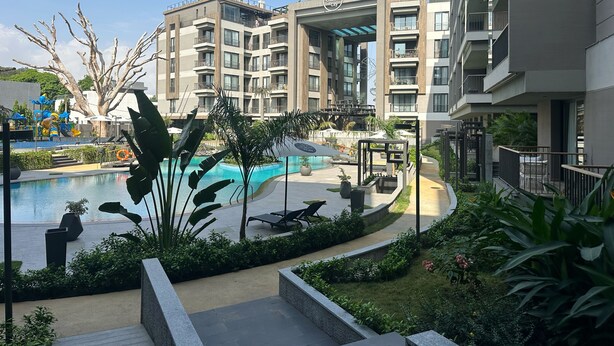 A modern hotel with a swimming pool, outdoor seating, and lush landscaping. - Charming 1-bedroom condo at The Diamond In City, Cantonments Accra. Luxe-Modern (Accra)