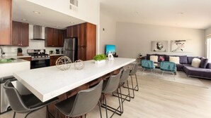 Una cocina moderna con armarios de madera oscura, electrodomésticos de acero inoxidable y encimera de mármol.