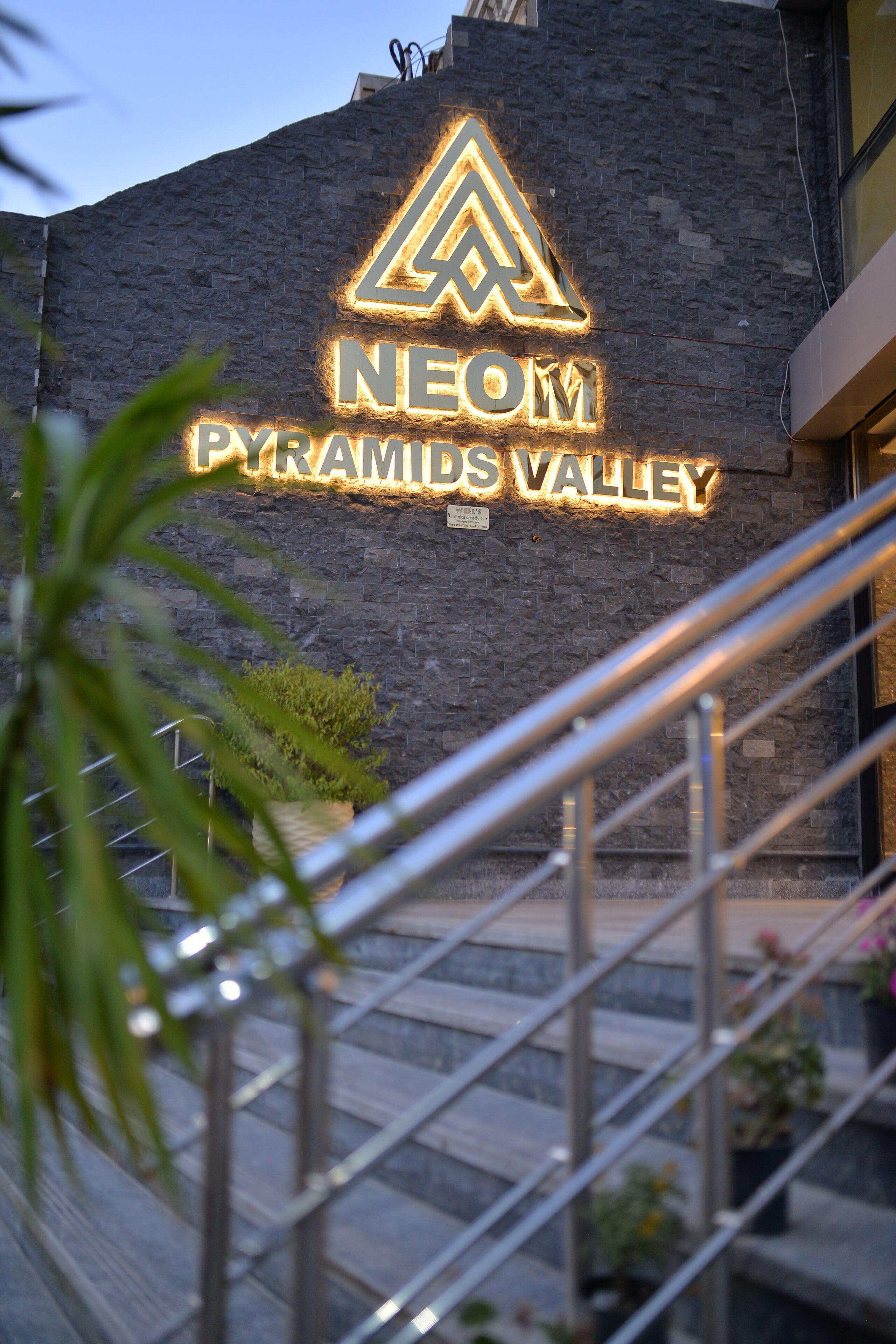 A building with a sign that reads "NEOM Pyramids Valley".