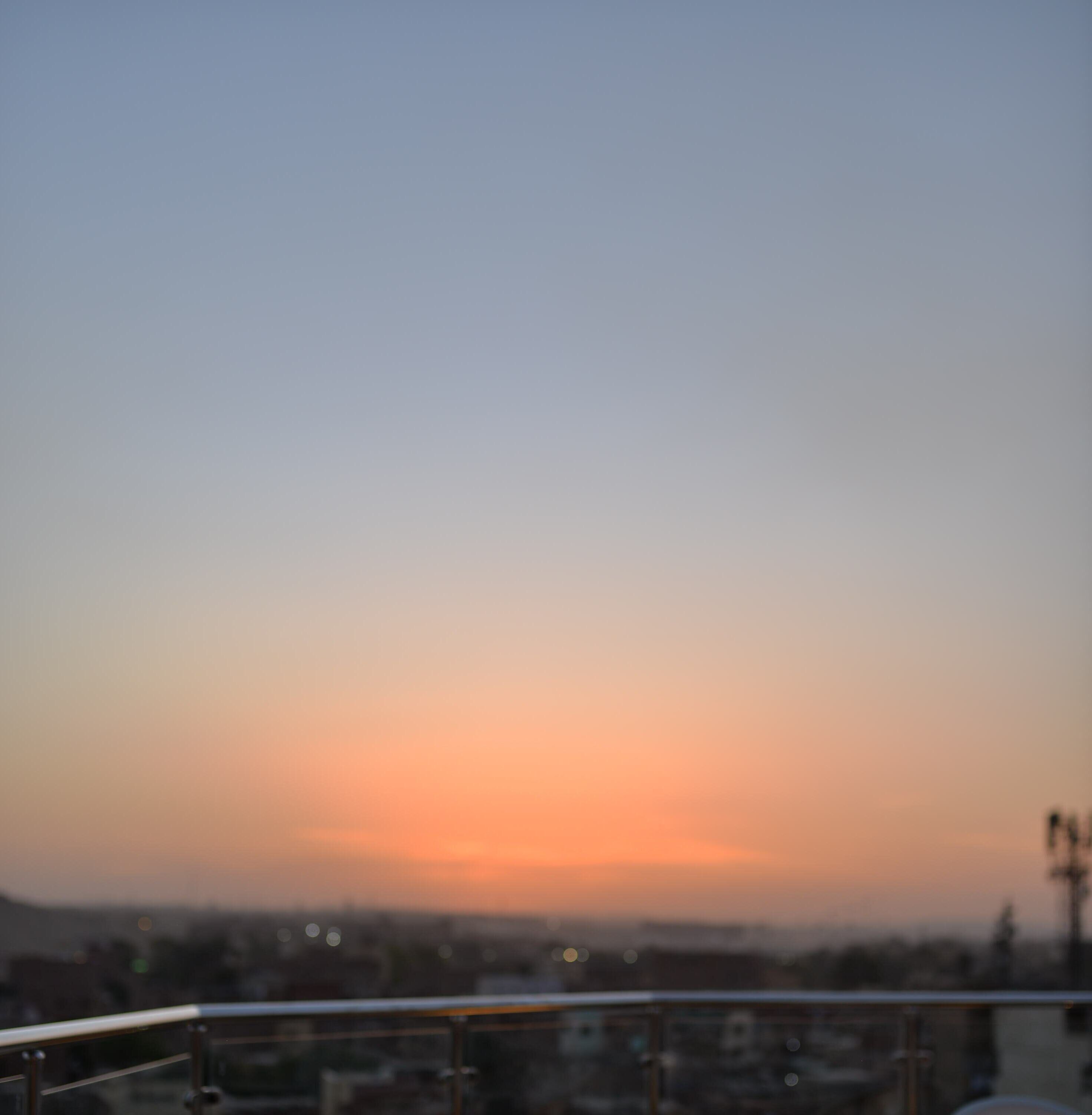 Ein Sonnenuntergangsblick von einem Balkon mit Metallgeländer.