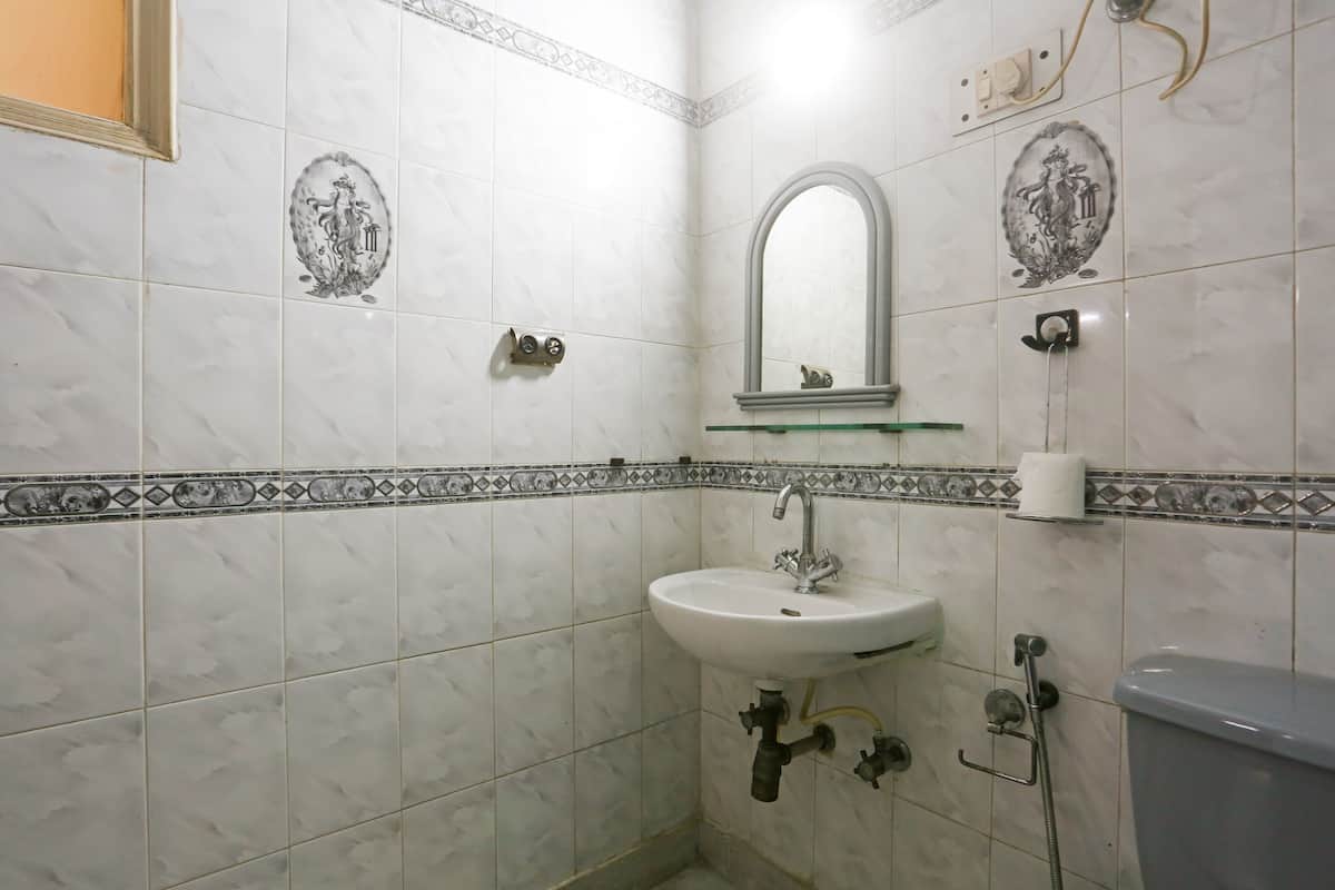 Een badkamer met een wit wastafelmeubel, spiegel en toilet.