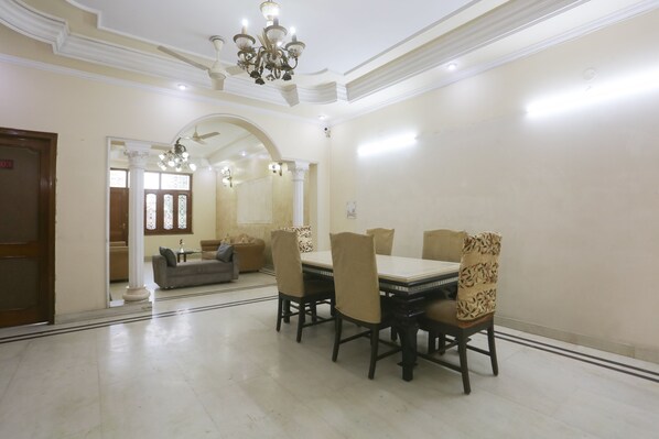 A dining area with a rectangular table, six chairs, and a chandelier.