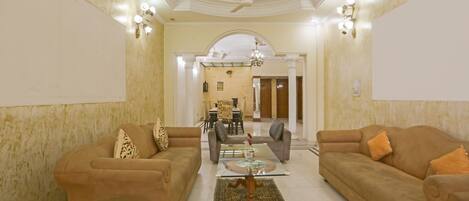 A spacious living room with two sofas, a coffee table, and a chandelier.