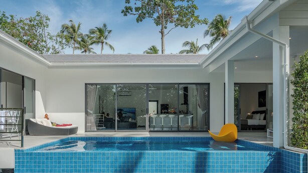 A modern house with a swimming pool, large windows, and a patio area.