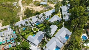 An aerial view of a resort with multiple buildings, including a swimming pool area and a greenhouse.