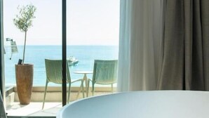 A modern bathroom with a large bathtub, a potted plant, and a view of the sea. - Saint Nicolas (Himarë)