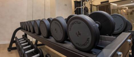 Una hilera de discos de pesas en un estante de gimnasio.