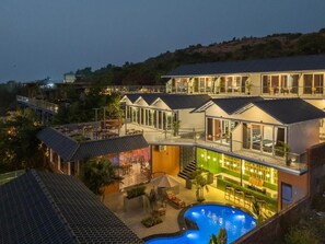 A modern hotel with multiple levels, outdoor seating, and a swimming pool. - The Hosteller Goa, Mandrem (Mandrem)
