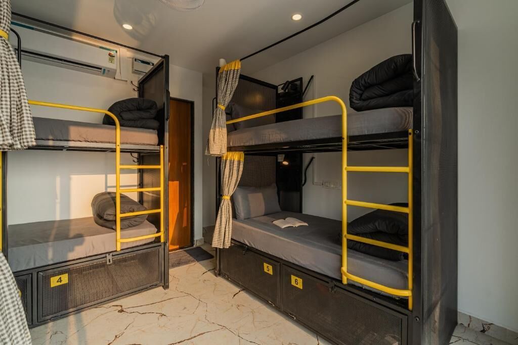 Un dormitorio con literas, compartimentos individuales numerados y un equipo de aire acondicionado.