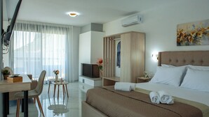 A hotel room with a bed, a desk with a chair, a TV, a wardrobe, and a painting on the wall. - Emma & Peris Villas-A Two Villa Retreat with Shared Courtyard,By IdealStay (Gouves)