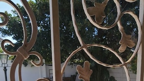 A metal gate with intricate designs, a pool, and a brick patio. - Beulah Lodge (Cape Town)